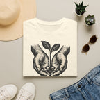 T-shirt — « Entre de bonnes mains » — Illustration graphique de mains tenant une jeune pousse