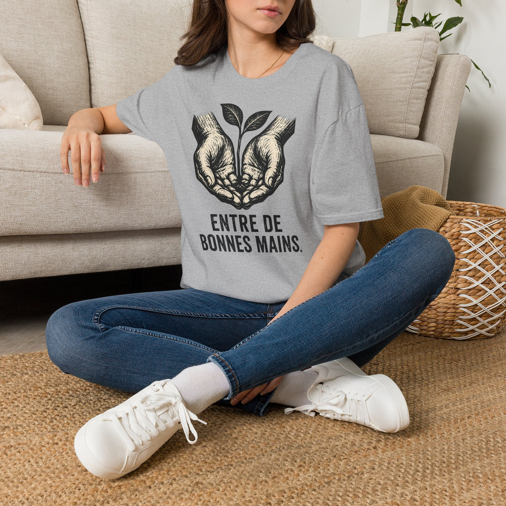 T-shirt — « Entre de bonnes mains » — Illustration graphique de mains tenant une jeune pousse